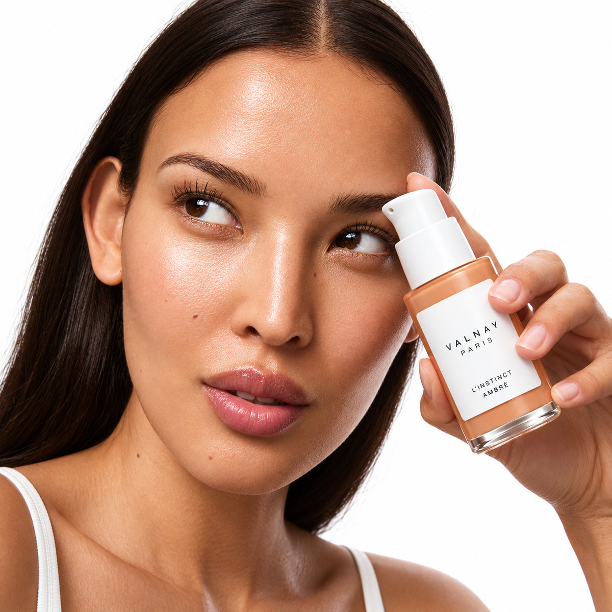 Femme tenant en main L’Instinct Ambré de Valnay, sérum anti-âge aux peptides pour lisser les rides et ridules et préserver la fermeté de la peau