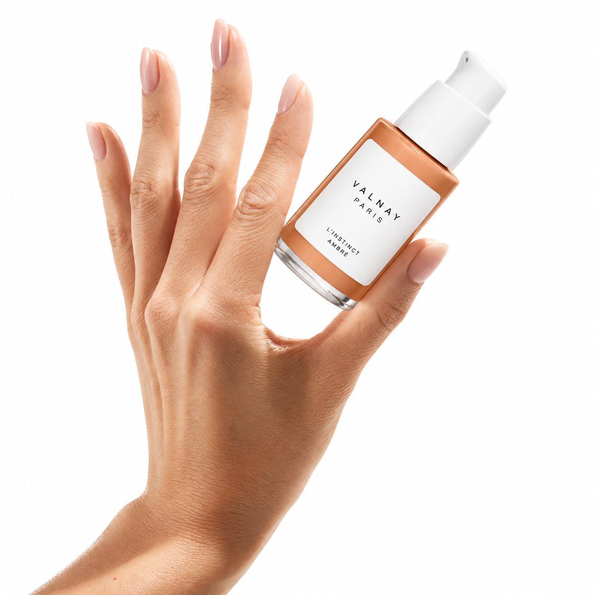 L’Instinct Ambré de Valnay, sérum anti-âge aux peptides, flacon tenu en main sur fond blanc, soin du visage pour une peau plus ferme, lisse et souple